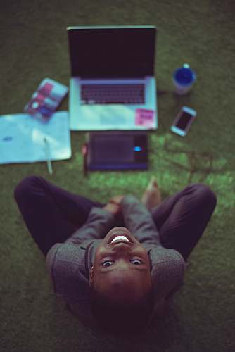smile top view photo of woman sitting near MacBook Pro facing the camera covenant university