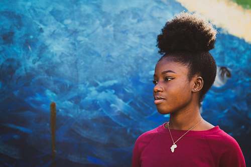 human woman standing near blue concrete wall person