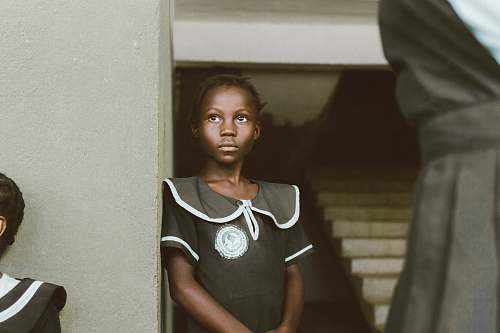 human girl leaning on white wall a liberia