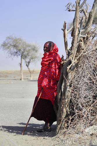 human man wearing red thawb robe holding cane people