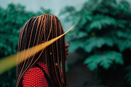 forest shallow focus of woman in dreadlocks during daytime fashion