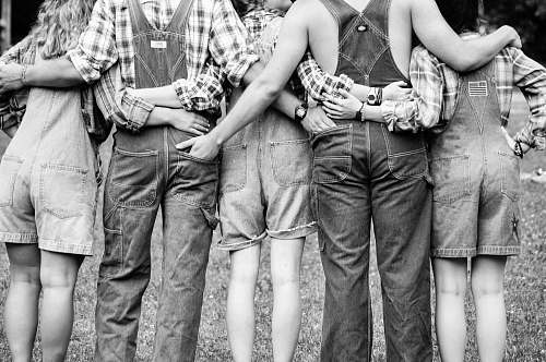 person grayscale photography of group of people hugging each other black-and-white