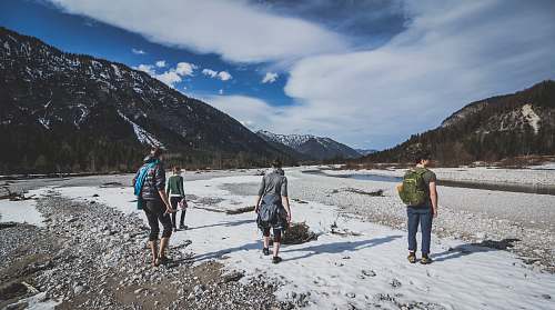 snow four people at mountain valley hiking