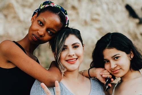 person three women posting for picture woman