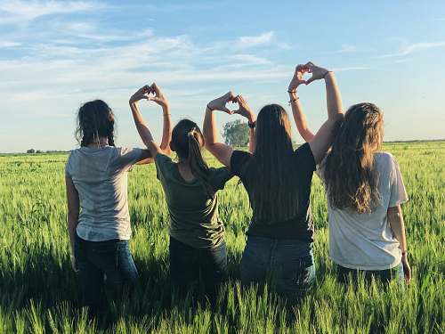 human women forming heart gestures during daytime person