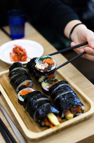 food person picking sushi using chopsticks cup