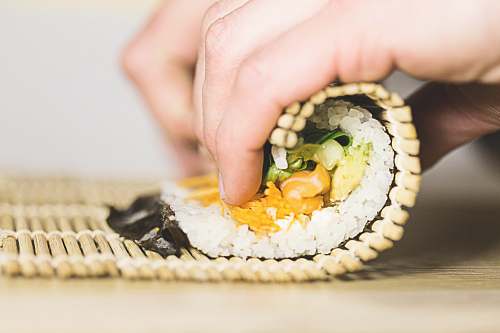 human person rolling sushi person