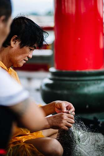 human man fixing fish net finger
