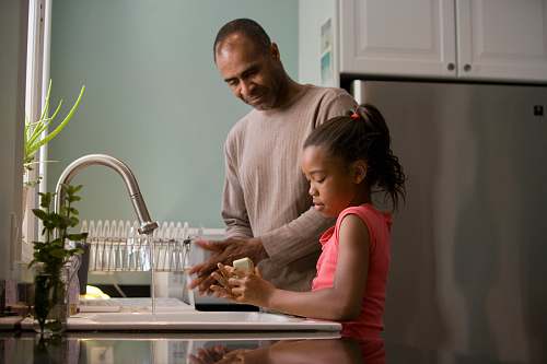 human man in white long sleeve shirt sitting beside woman in pink long sleeve shirt sink