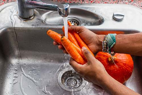 human person washing carrots washing