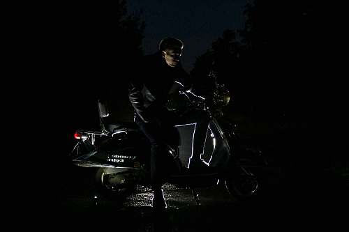 black man sitting on motorcycle dark