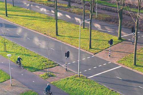 road 2 men walking on gray concrete road during daytime bicycle