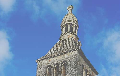 building low angle view photography of brown stone cathedral bell tower