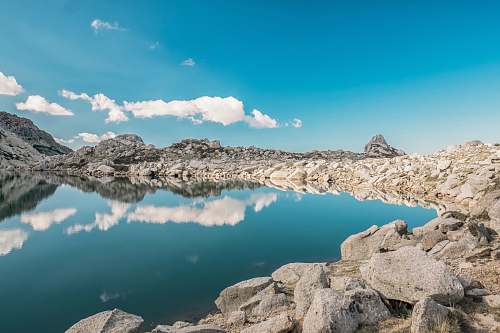 rock body of water surrounded by rock mountain