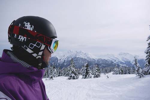 ski man wearing black helmet and snow goggles under white sky helmet
