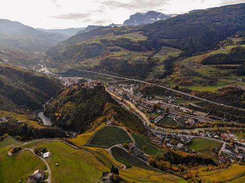 outdoors aerial photography of green fields and concrete roads at daytime scenery