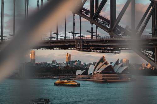 building white boat beside Sydney Opera HOuse bridge