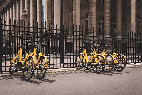 bike yellow bicycles beside black fence transportation