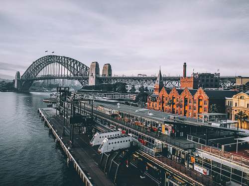 australia aerial photography of concrete buildings and bridge beside ocean under cloudy sky sydney