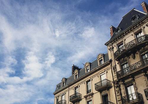 city white and black concrete building under white cloud and blue sky during daytime town