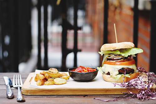 cutlery ham burger beside bowl on tray burger