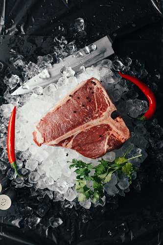 steak raw meat on ice with coriander and chilis lobster