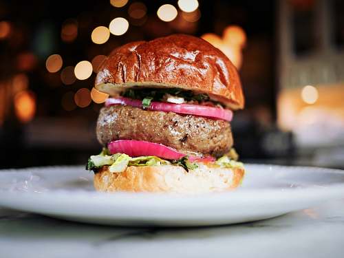 burger shallow focus photography of hamburger on white ceramic plate restaurant