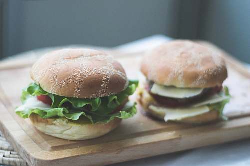 burger two burgers on brown wooden chopping board hamburger