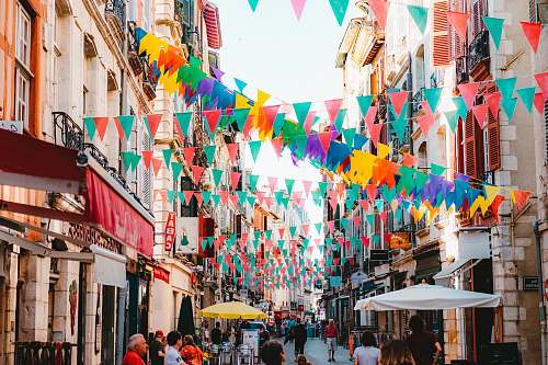 umbrella photo of assorted-color buntings placed on buildings during daytime canopy