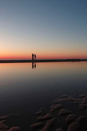 sunset two person standing on beach dock wissant