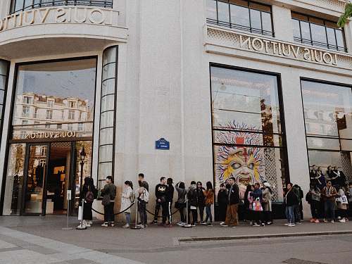 person people queuing beside Louis Vuitton store people
