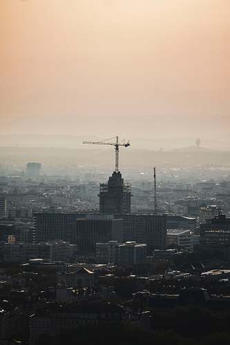 building photo of red crane on top of gray building fog