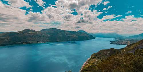 nature body of water and mountains during day land