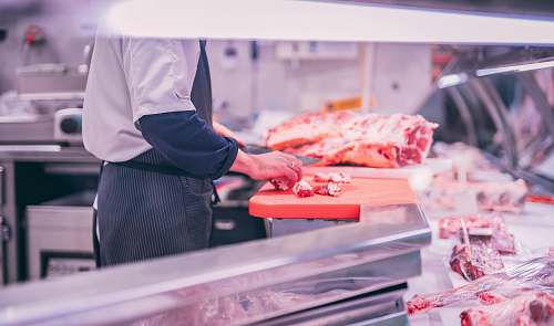 human man slicing raw meat shop