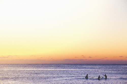 ocean three person playing on ocean during golden hour australia