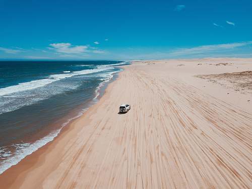 beach white SUV on seashore ocean