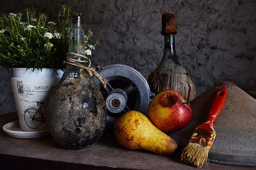fruit vase beside flower pot and fruits on table produce