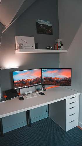 table two flat screen computer monitors inside room furniture