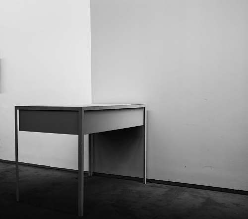 furniture white wooden desk beside white wall black-and-white