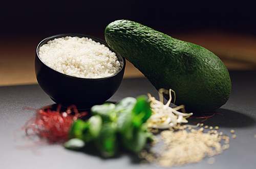 plant avocado fruit near cooked rice and sliced green bell pepper avocado