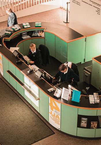 desk man in black jacket sitting beside brown wooden desk table