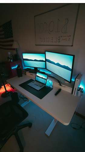 desk two flat screen monitors table
