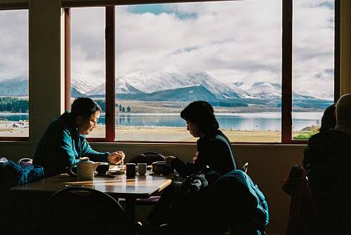 human man an woman having breakfast with the view of mountain restaurant