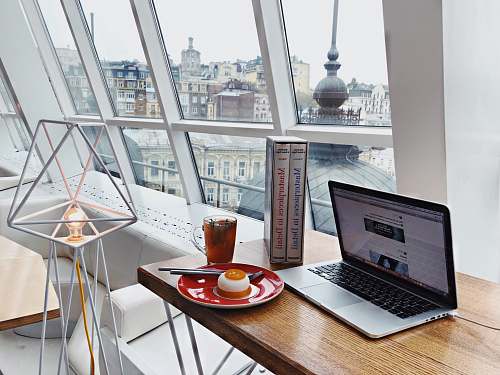 furniture MacBook Pro near food on red plate on brown wooden table electronics