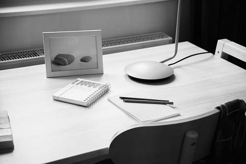 furniture notebook on desk near photo frame black-and-white
