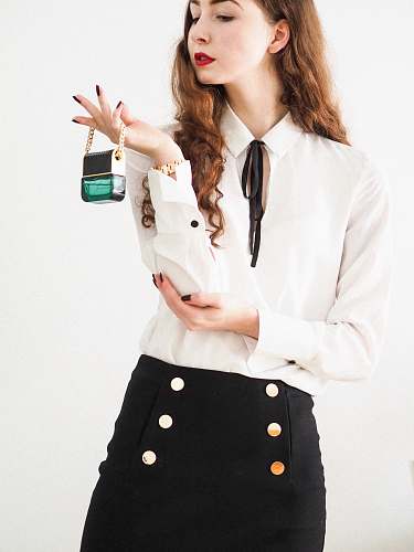 female woman in white blazer holding green and white ceramic mug accessories