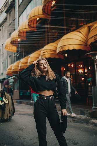 clothing woman standing near people and building during day apparel
