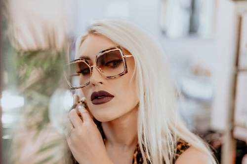 person woman wears dark brown matte lipstick and oversized sunglasses sunglasses