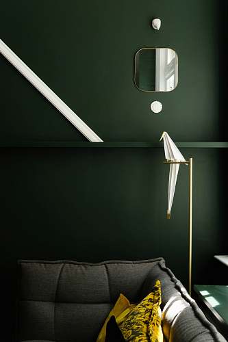 human square framed mirror over gray sofa person