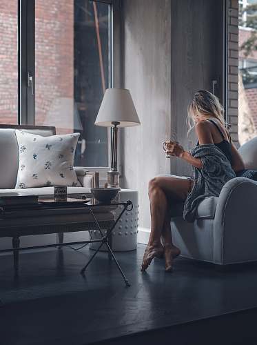 manhattan woman sitting on gray sofa chair holding mug new york
